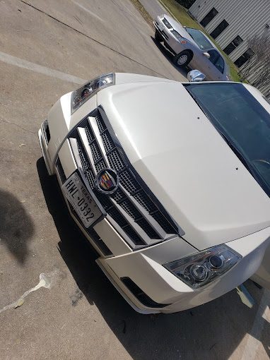 Close-up of the chrome grille and headlamp of a white Cadillac Escalade
